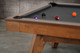 Three-quarter view of the Doc & Holliday Scholar Slate Pool Table in Heritage Maple finish | Solid maple hardwood with flared mid-century modern legs and premium slate bed | Photographed in a high-end interior setting with black felt playfield | USA-made luxury pool table by Doc & Holliday Billiards Three-quarter view of the Doc & Holliday Scholar Slate Pool Table in Heritage Maple finish | Solid maple hardwood with flared mid-century modern legs and premium slate bed | Photographed in a high-end interior setting with black felt playfield | USA-made luxury pool table by Doc & Holliday Billiards